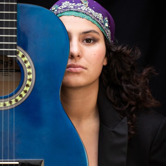 portrait de studio jeune musicienne avec son guitar bleu
